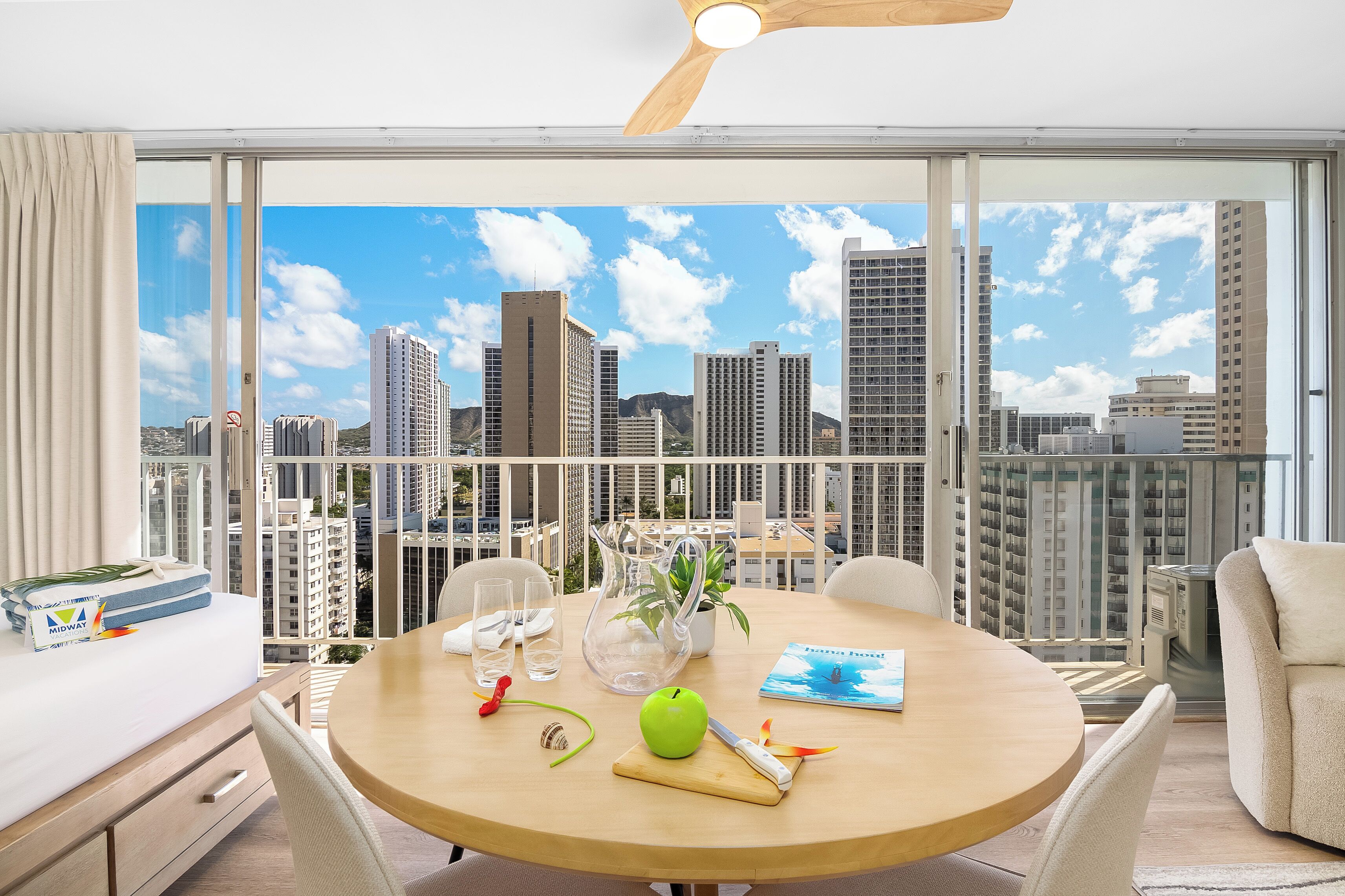 Une chambre moderne avec un balcon, une table ronde, un lit et une vue sur la ville.