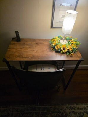 Una mesa de comedor con una lámpara y un centro de mesa floral.