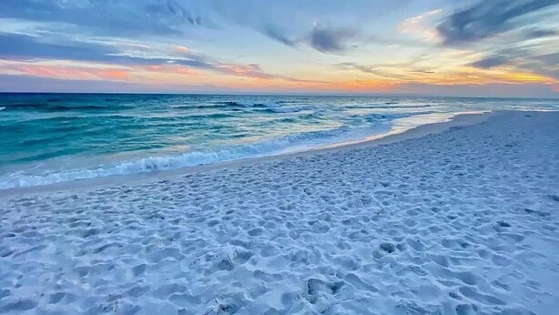 Une plage de sable blanc avec vue sur l’océan.