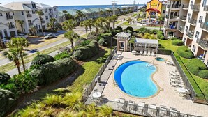 Un complexe hôtelier doté d’une piscine, de palmiers et offrant une vue sur l’océan.