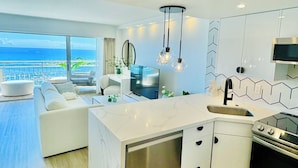 A modern kitchen with a built-in dishwasher, a stainless steel oven, and a large island with a sink. - Panoramic Oceanview Home (Car Available) (Honolulu)
