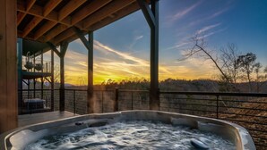 Ein Whirlpool mit Holzterrasse und Blick auf den Sonnenuntergang.