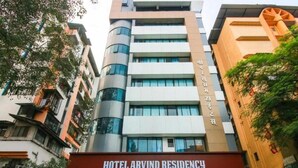 A multi-story building with a sign reading "HOTEL ARVIND RESIDENCY". - Glitz Hotels AR Residency (Thane)