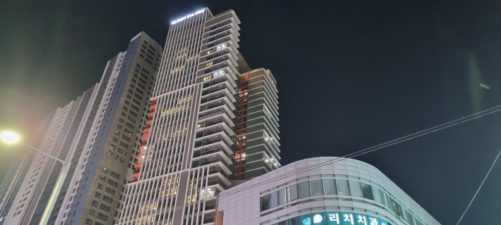 A high-rise building with multiple floors and balconies, featuring a modern architectural design.