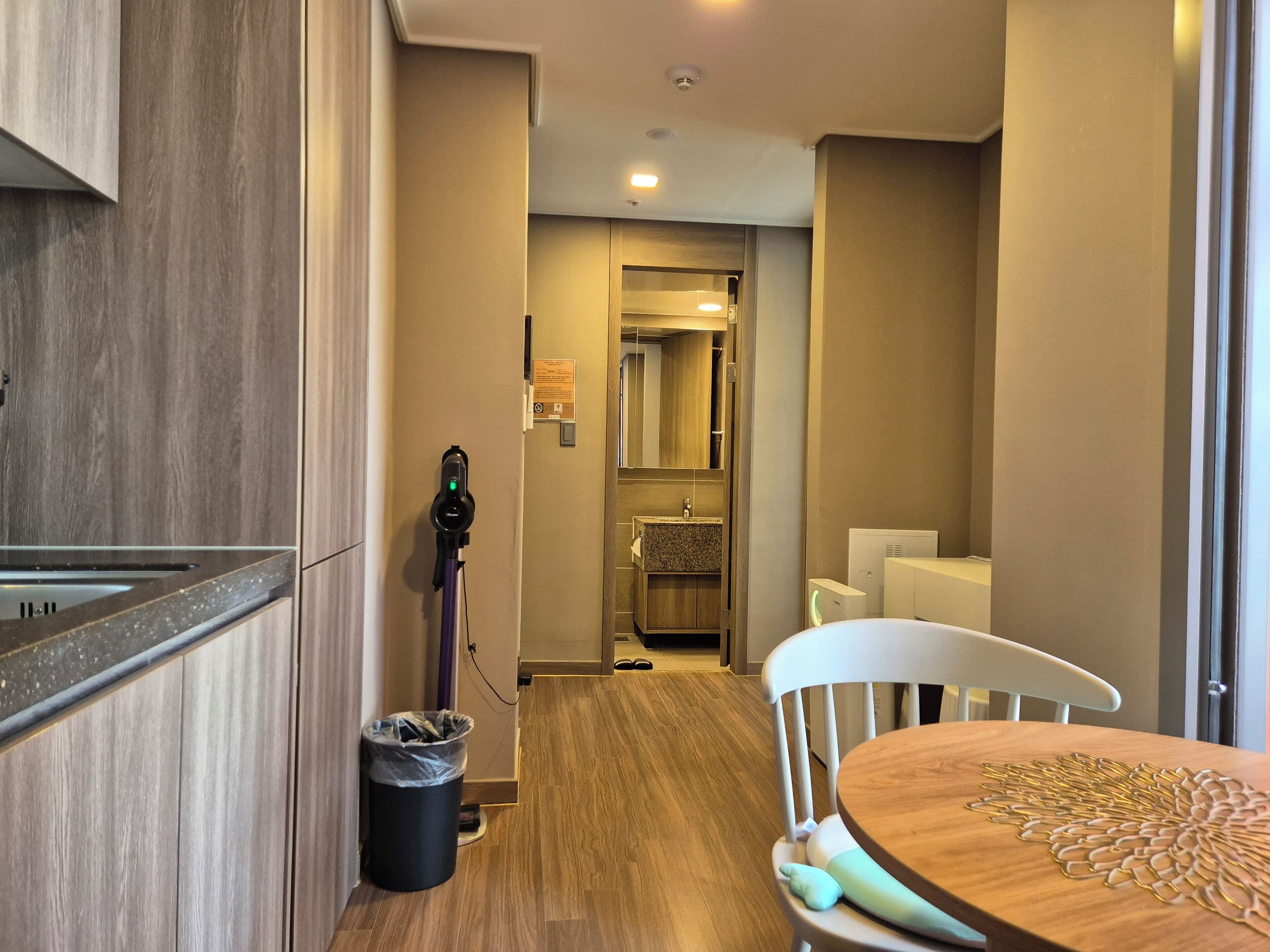 A modern kitchen with a built-in stove, a charging station, and a trash bin.