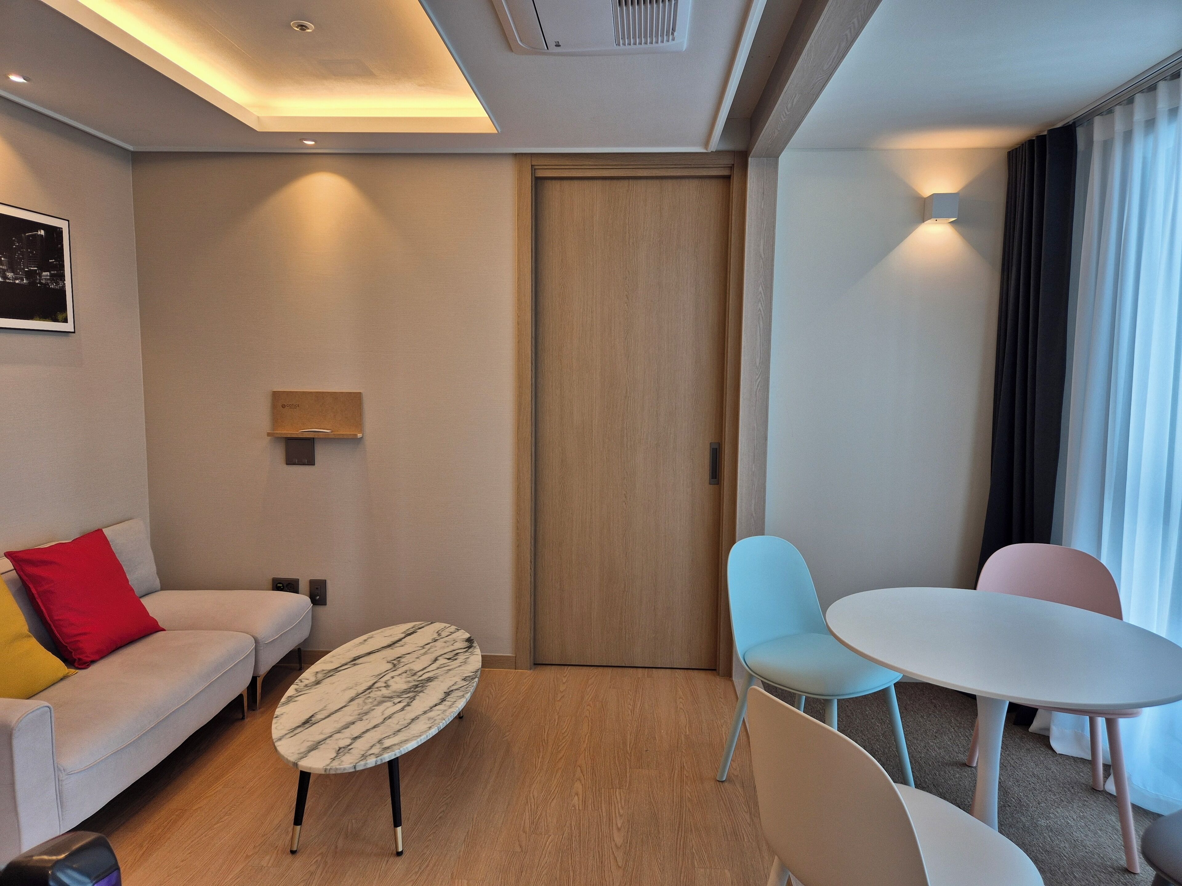 Une chambre d’hôtel moderne avec un canapé, une table ronde et deux chaises.