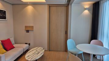 Une chambre d’hôtel moderne avec un canapé, une table ronde et deux chaises.