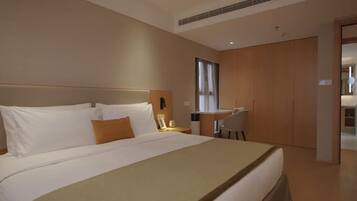 Una habitación de hotel con una cama grande, un escritorio y un armario.