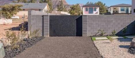 A residential area with a paved driveway leading to a gated entrance.