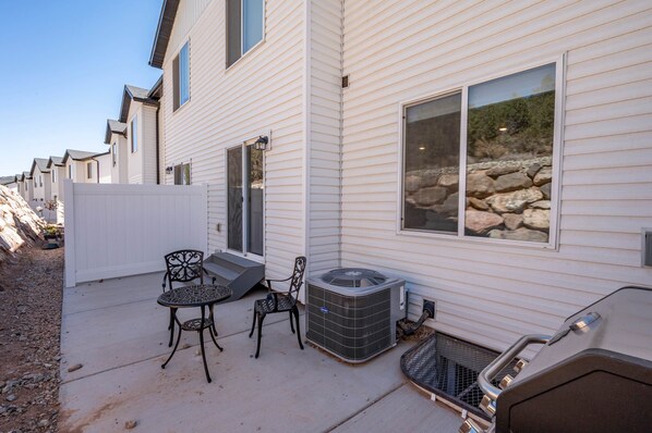 A residential area with a patio, outdoor furniture, and a grill.