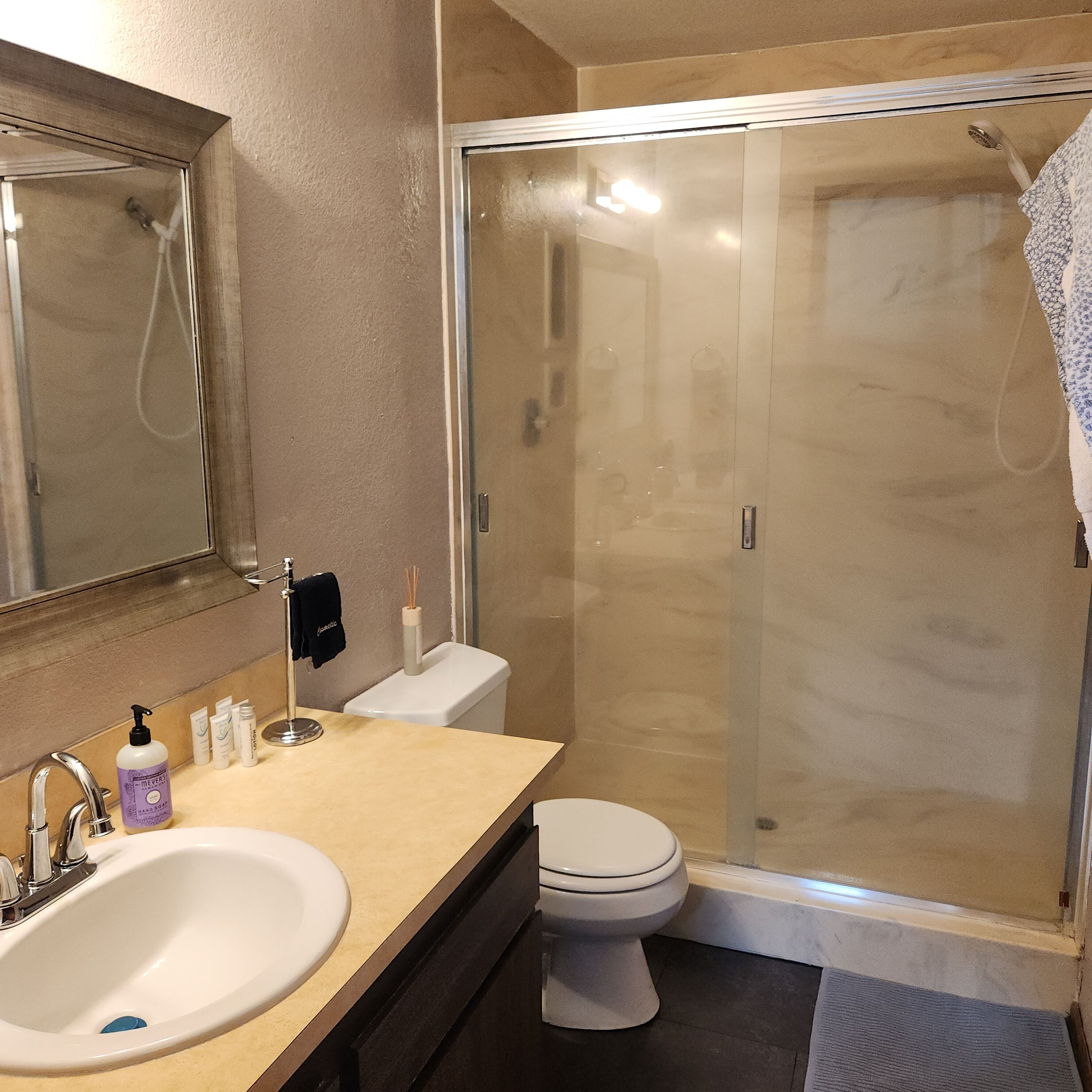 Une salle de bain équipée d’un lavabo, de toilettes et d’une douche à parois de verre.