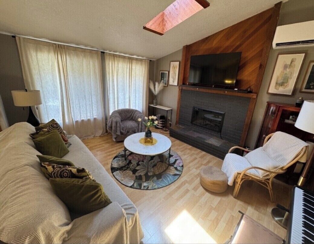 living room has a keyboard piano, big tv, an electric fireplace 
