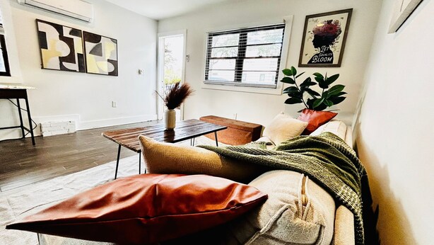 Een moderne woonkamer met een bank, een salontafel en een eethoek.