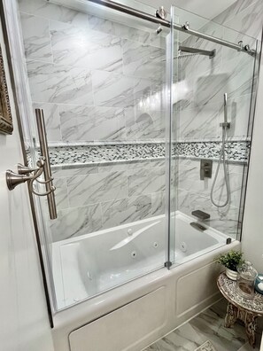 Douche, baignoire à remous, séchoir à cheveux, serviettes fournies