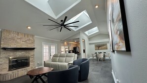 A spacious living room with a fireplace, comfortable seating, and a skylight ceiling. - A&C WATERFORD COTTAGE # 1 (Victoria)