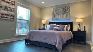 A bedroom with a bed, two bedside tables, a ceiling fan, a window, and artwork on the walls. - A&C WATERFORD COTTAGE # 1 (Victoria)