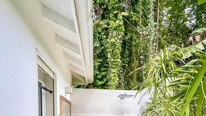 A modern bathroom with a freestanding bathtub, a wooden vanity, and a shower area.