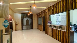 A reception area with a reception desk, a waiting area, and a hallway leading to a door. - Sawasstika Eco Park Resort  (Jalpaiguri)