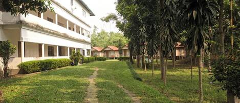 A courtyard with a pathway leading to a white building with multiple balconies.