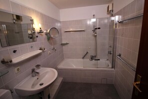 Un baño moderno con bañera, ducha y lavamanos.