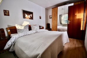 Ein Schlafzimmer mit einem großen Bett, einem Holzkopfende und einem Schrank aus Holz.