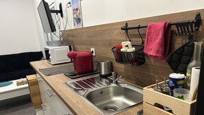 Una cucina moderna con lavello in acciaio inossidabile, piano di lavoro in legno e macchina per il caffè nera.