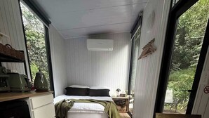Een moderne slaapkamer met een bed, een klein tafeltje en een bankje.