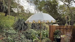 Een houten terras met een tuin, inclusief verschillende planten en een decoratieve parasol.