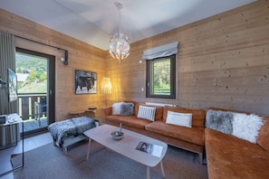 A cozy living room with a sofa, coffee table, and a fireplace.