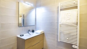 A modern bathroom with a white sink, mirror, and towel rack. - APARTMENT  CHÂTEL - O Rouge A204 (CHATEL)