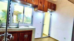 A kitchen with wooden cabinets, a window, and a sink.
