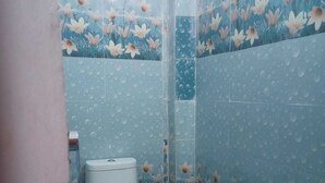 A small bathroom with a toilet and shower area. - Shree Sitaram Guest House (Faizabad)