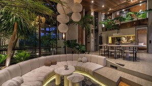 A modern indoor space with a curved seating area, a dining area, and a kitchen. - Cala Galeo (Munggu)