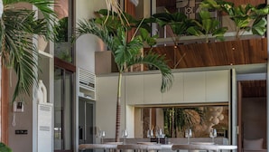 A modern interior with a dining area, seating, and a staircase. - Cala Galeo (Munggu)