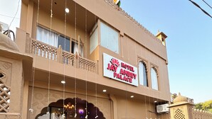 A hotel entrance with a checkered floor, a sign reading "Hotel Jay Ambey Palace," and a flag on top. - Jay Ambey Palace (Amer)