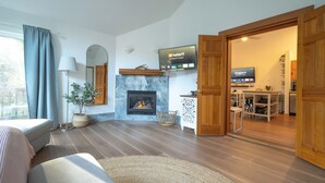 A modern living room with a fireplace, a flat-screen TV, and a dining area. - Tolovana 3 - 700ft to Beach - Family Fun - Dogs Ok! (Cannon Beach)