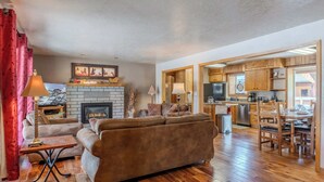 A living room with a fireplace, sofa, and dining area.