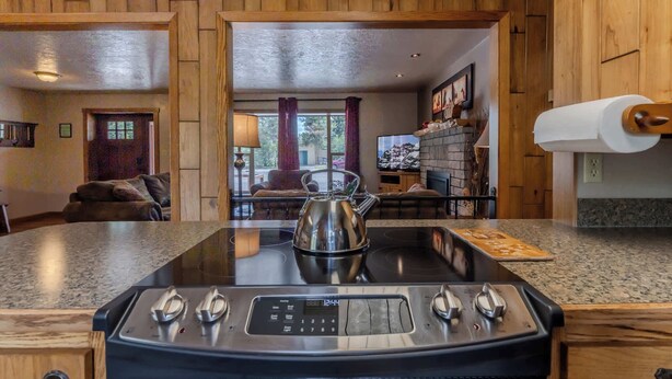 A kitchen with a built-in stove, a kettle, and a countertop.