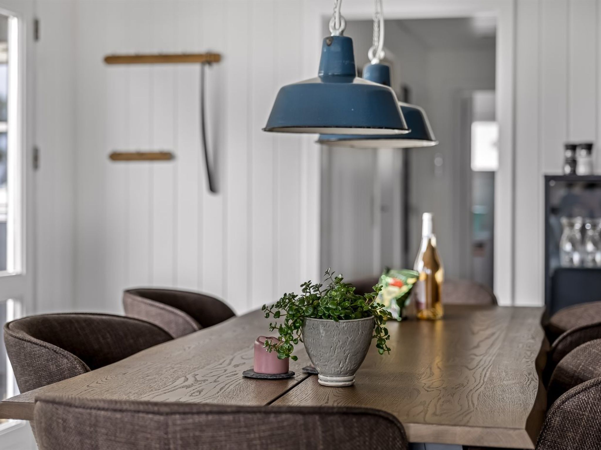 En matplats med ett träbord, stolar och en hängande lampa.