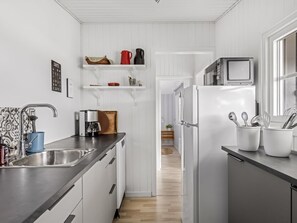 A modern kitchen with white cabinetry, a stainless steel sink, and a built-in microwave.