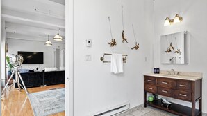 Une salle de bain moderne avec un meuble-lavabo, un miroir et un porte-serviettes.