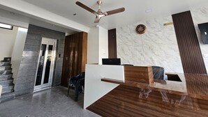 Ein moderner Empfangsbereich mit Marmorwand, Holzvertäfelung und Deckenventilator.