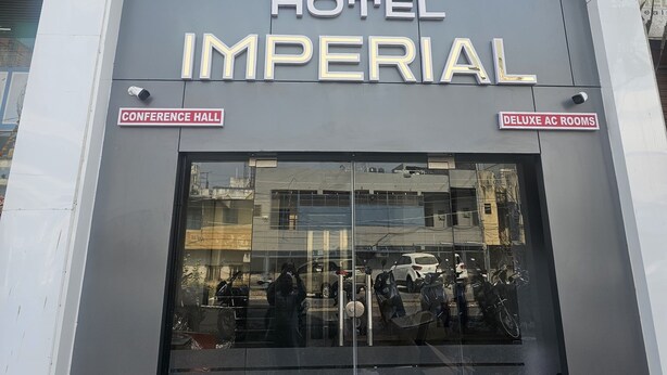 Ein Hotel namens "Imperial" mit einem Schild, das "Konferenzraum" und "Deluxe Klimaanlagenzimmer" anzeigt.