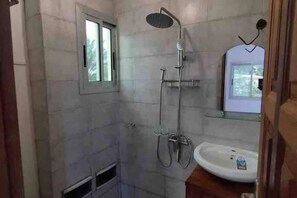 Een douche, handdoeken, zeep, toiletpapier