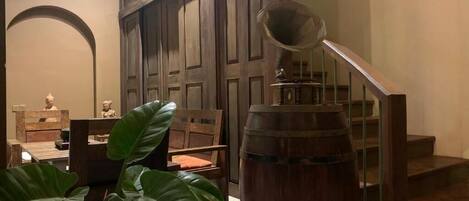 A staircase with a wooden handrail and a large barrel in the foreground.