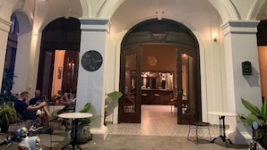Egy íves mennyezetű, elegáns hotelhall, bárral és különböző ülőhelyekkel.