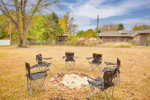 Relax in a serene outdoor setting with a fire pit and comfortable seating for five.