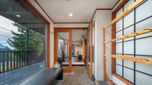 Ein traditionelles japanisches Interieur mit Tatami-Böden, einer Schiebetür und Blick ins Freie.