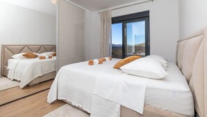 A modern bedroom with a large bed, a mirror, and a view of the outdoors. - Luxurious Sanctuary Villa Primorski Dolac With Pool (Primorski Dolac)
