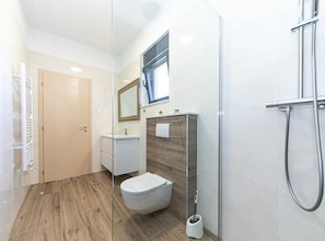 A modern bathroom with a wooden floor, a toilet, a sink, a mirror, and a shower. - Luxurious Sanctuary Villa Primorski Dolac With Pool (Primorski Dolac)